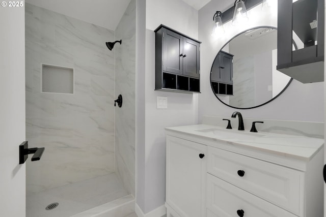 bathroom featuring tiled shower and vanity