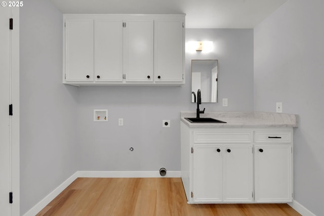 laundry room featuring gas dryer hookup, sink, washer hookup, light hardwood / wood-style floors, and hookup for an electric dryer