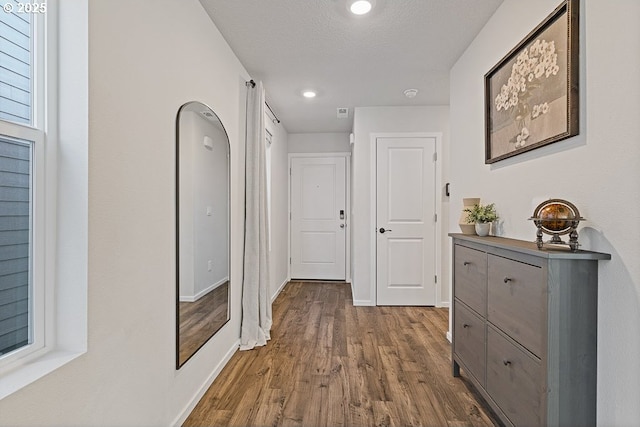 hallway featuring dark wood-type flooring and a textured ceiling