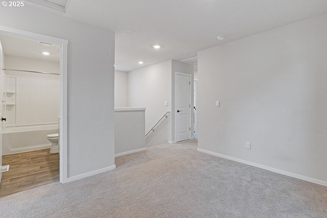 empty room with light carpet and a textured ceiling