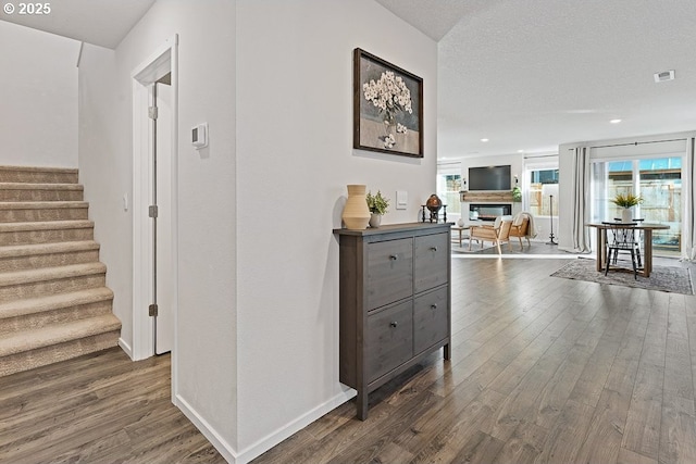 hall with dark hardwood / wood-style flooring and a textured ceiling