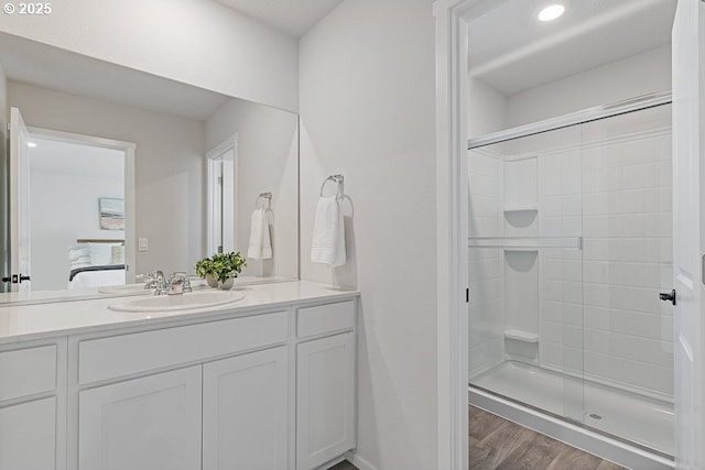 bathroom featuring vanity, hardwood / wood-style flooring, and a shower with shower door