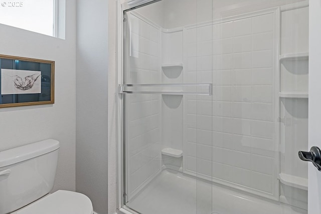 bathroom featuring toilet and an enclosed shower