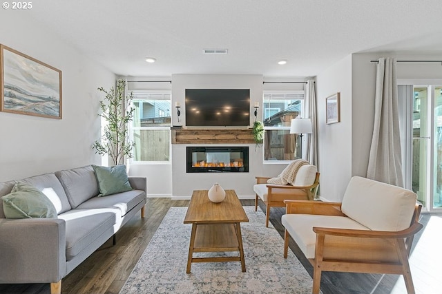 living room featuring plenty of natural light, a textured ceiling, and dark hardwood / wood-style flooring