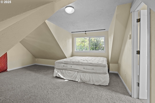 carpeted bedroom with baseboards, a textured ceiling, and lofted ceiling