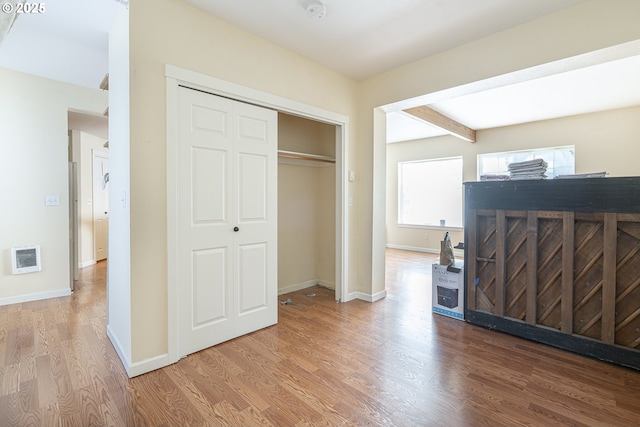 bedroom with light wood finished floors, a closet, and baseboards