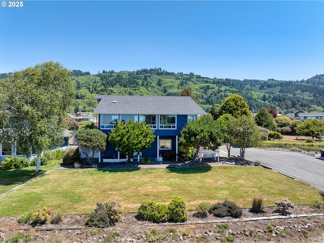 15263 Oceanview Dr, Brookings, OR 97415 - view of front of house featuring a wooded view and a front lawn