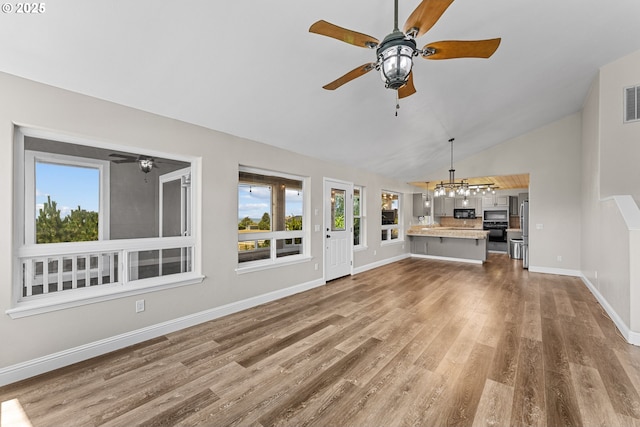 15263 Oceanview Dr, Brookings, OR 97415 - unfurnished living room featuring plenty of natural light, a chandelier, wood finished floors, ceiling fan, and high vaulted ceiling