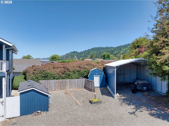 15263 Oceanview Dr, Brookings, OR 97415 - fenced backyard with a shed, a carport, and a mountain view