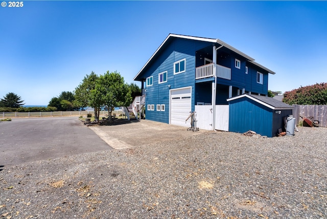 15263 Oceanview Dr, Brookings, OR 97415 - view of side of property featuring a balcony, stairs, driveway, and an attached garage