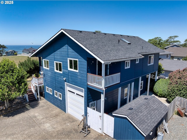 15263 Oceanview Dr, Brookings, OR 97415 - back of property featuring roof with shingles, stairway, a water view, driveway, and a balcony