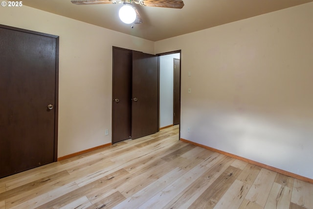 unfurnished bedroom featuring a ceiling fan, light wood-style flooring, and baseboards