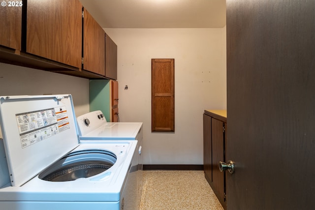 laundry room with cabinet space, baseboards, and separate washer and dryer