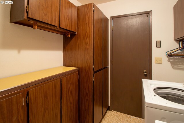 clothes washing area with cabinet space and washer / dryer