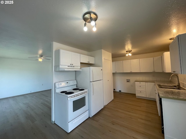 755735 Bluff Ave, Bandon, OR 97411 - kitchen with white appliances, a sink, under cabinet range hood, wood finished floors, and white cabinets