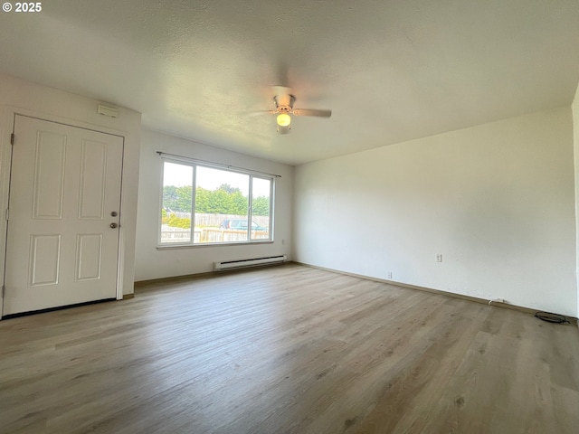 755735 Bluff Ave, Bandon, OR 97411 - unfurnished room featuring a ceiling fan, a baseboard radiator, light wood-style flooring, and baseboards