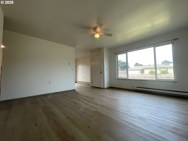 755735 Bluff Ave, Bandon, OR 97411 - unfurnished living room with a baseboard heating unit, a ceiling fan, wood finished floors, and baseboards