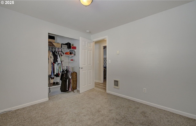 unfurnished bedroom featuring light colored carpet and a closet