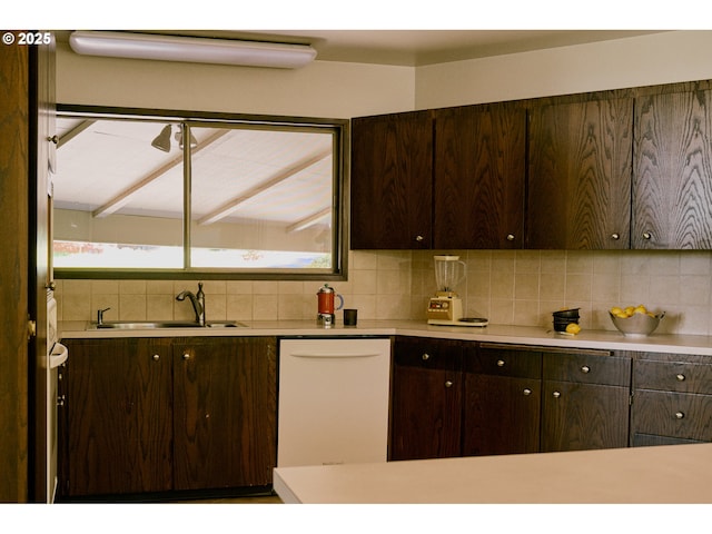 kitchen featuring decorative backsplash, dark brown cabinetry, white dishwasher, light countertops, and a sink
