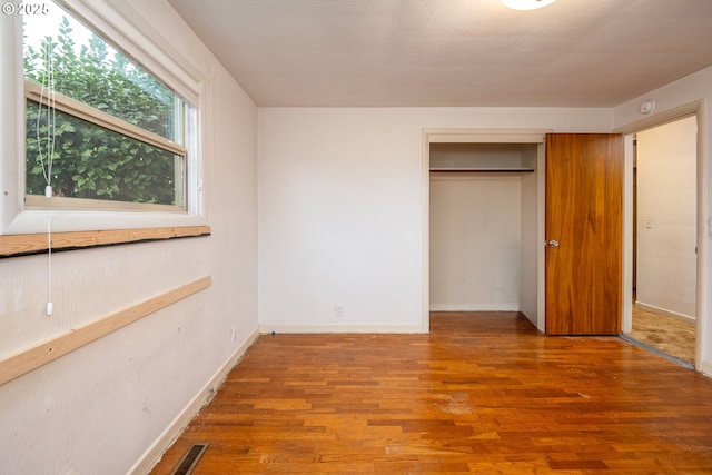 unfurnished bedroom featuring hardwood / wood-style floors and a closet