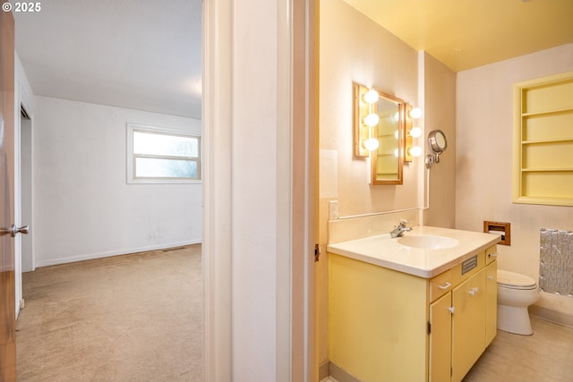 bathroom featuring vanity, toilet, and built in features