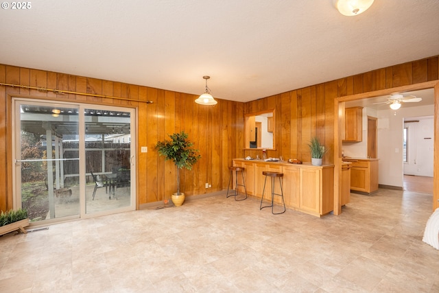 4160 Willhi St, Eugene, OR 97402 - kitchen with decorative light fixtures, a kitchen bar, wooden walls, and kitchen peninsula