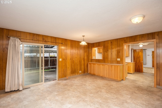 empty room featuring wooden walls and a textured ceiling