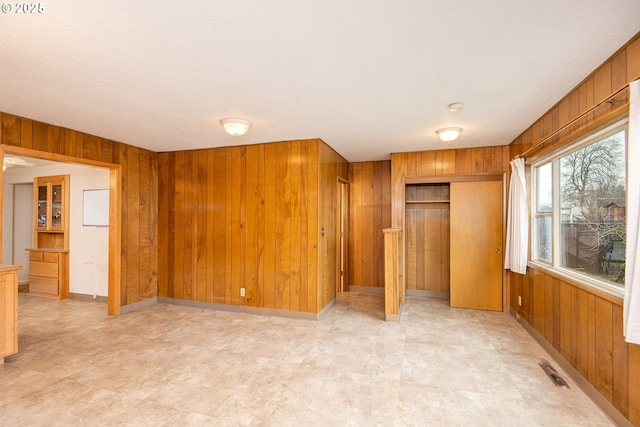 interior space featuring multiple closets and wood walls