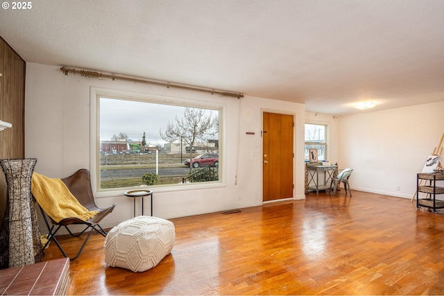 living area featuring a textured ceiling and hardwood / wood-style floors