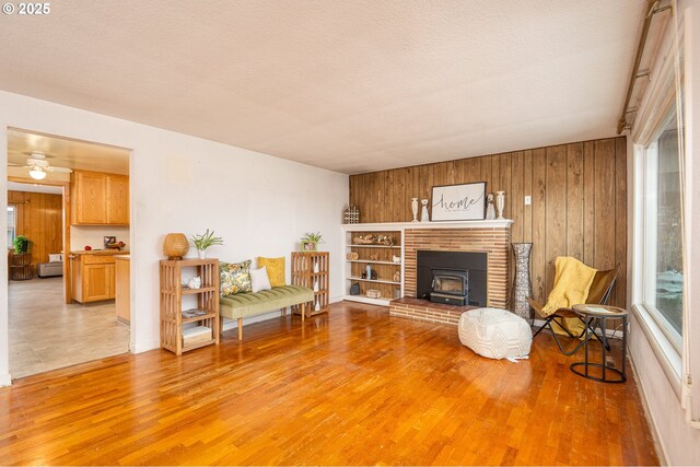 4160 Willhi St, Eugene, OR 97402 - living room featuring wooden walls, wood-type flooring, a textured ceiling, and a healthy amount of sunlight