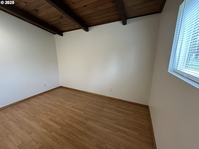 empty room featuring wooden ceiling, baseboards, beam ceiling, and wood finished floors