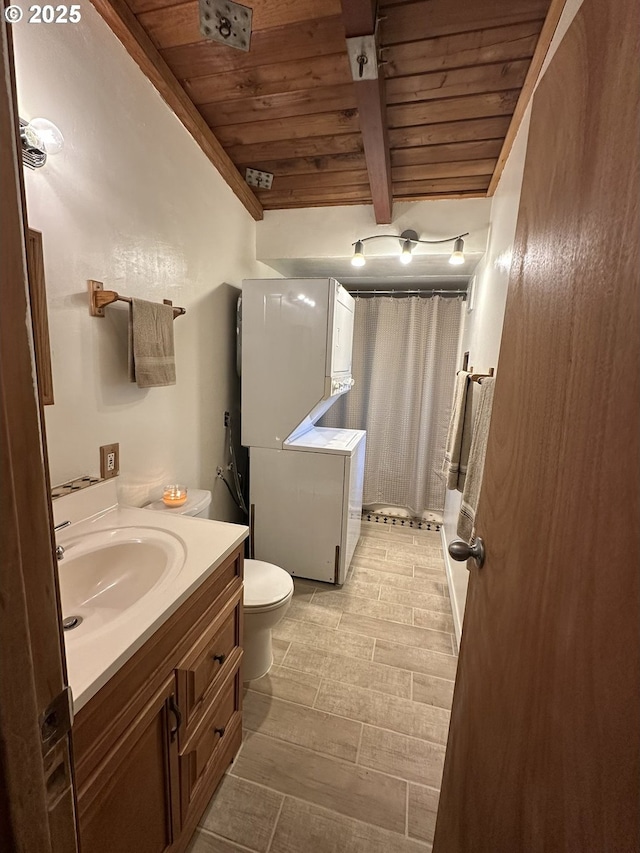 bathroom featuring wood ceiling, stacked washer and clothes dryer, beamed ceiling, and vanity