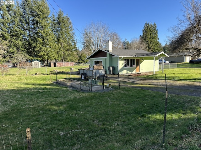 view of front of property with a garden, a chimney, fence, and a front yard