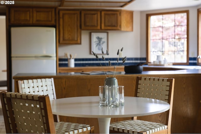 kitchen featuring brown cabinetry and freestanding refrigerator