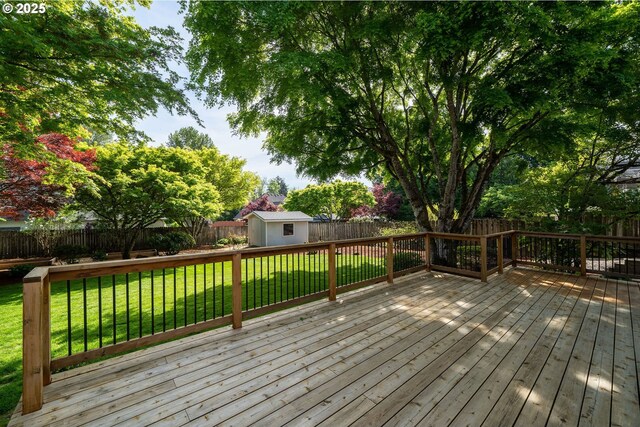 wooden deck with a fenced backyard, an outbuilding, a yard, and a storage shed