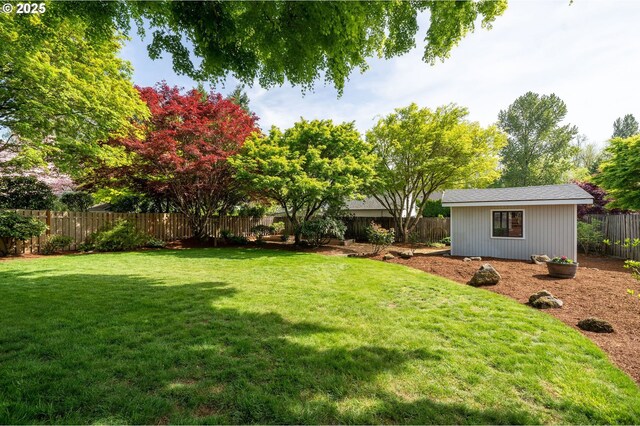 view of yard with an outdoor structure and a fenced backyard