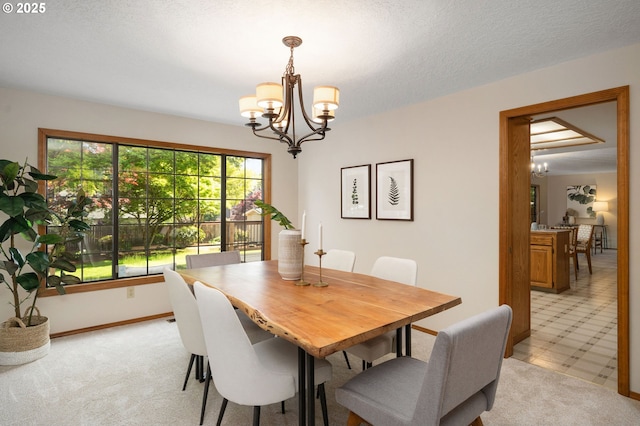 dining area featuring light carpet, a wealth of natural light, and a chandelier