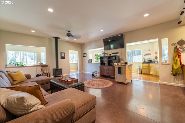 94986 Thetford Ln, Marcola, OR 97454 - living area with a wood stove, recessed lighting, concrete floors, baseboards, and ceiling fan