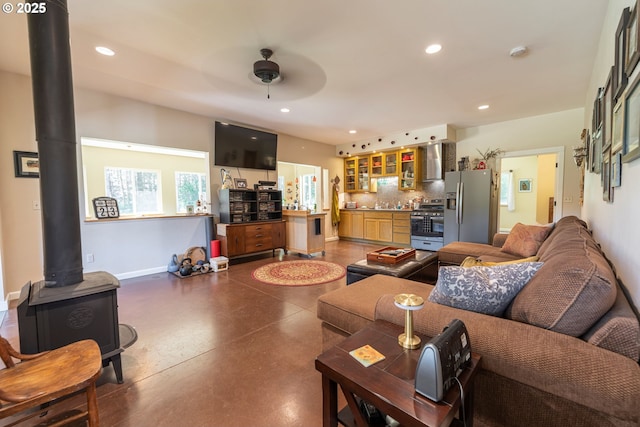 94986 Thetford Ln, Marcola, OR 97454 - living room with baseboards, recessed lighting, concrete floors, a wood stove, and ceiling fan