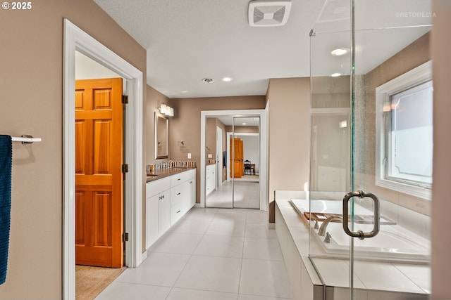 bathroom with a washtub, a shower with door, visible vents, vanity, and tile patterned flooring