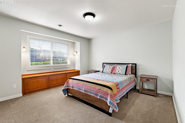 bedroom featuring visible vents, light carpet, a textured ceiling, and baseboards