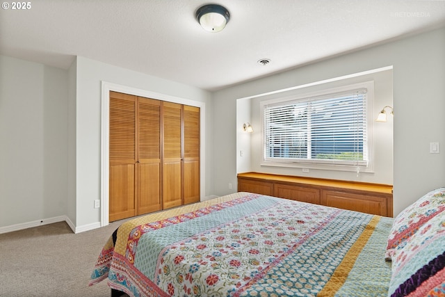 carpeted bedroom with baseboards and a closet