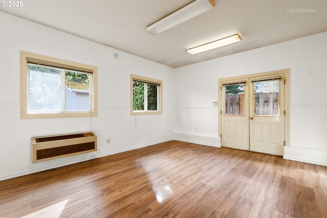 spare room featuring wood finished floors and heating unit