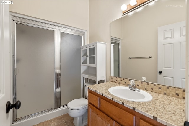 bathroom featuring backsplash, toilet, a shower stall, vanity, and tile patterned floors