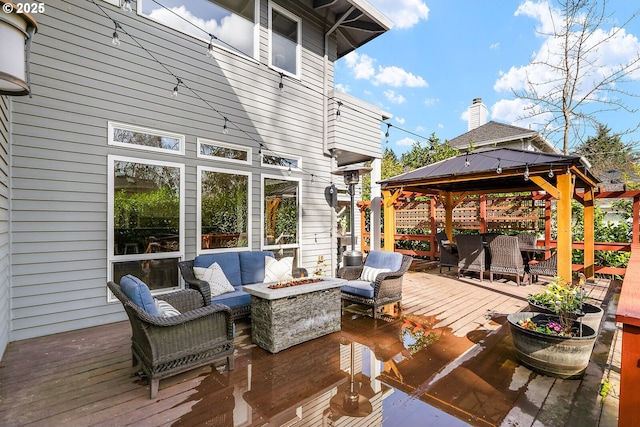 wooden terrace with an outdoor living space with a fire pit and a gazebo