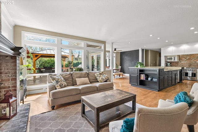 living area featuring light wood-style floors, recessed lighting, and ceiling fan