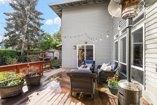 wooden terrace with an outdoor living space