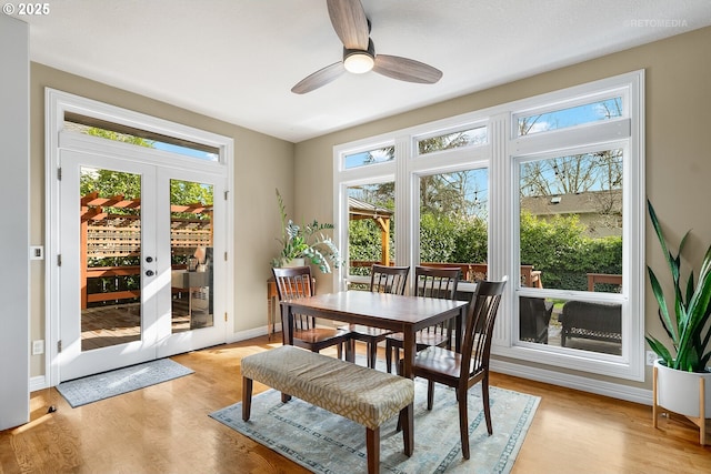 sunroom with a ceiling fan and french doors