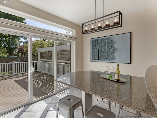 dining space with tile patterned floors and a chandelier