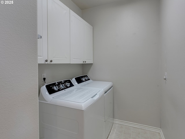 clothes washing area with cabinet space, independent washer and dryer, and baseboards